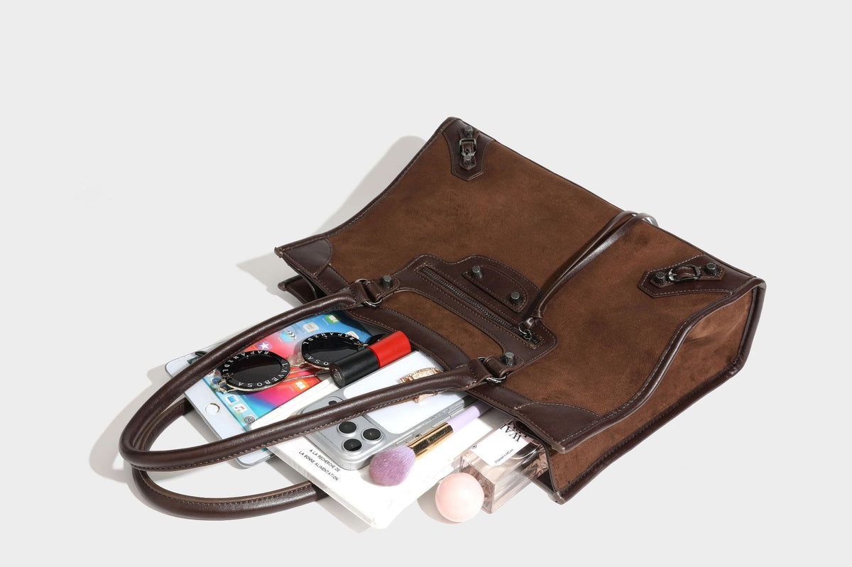 Large structured tote bag with matte suede-like body, smooth leather-look trim, front zip pocket, stud hardware, and
