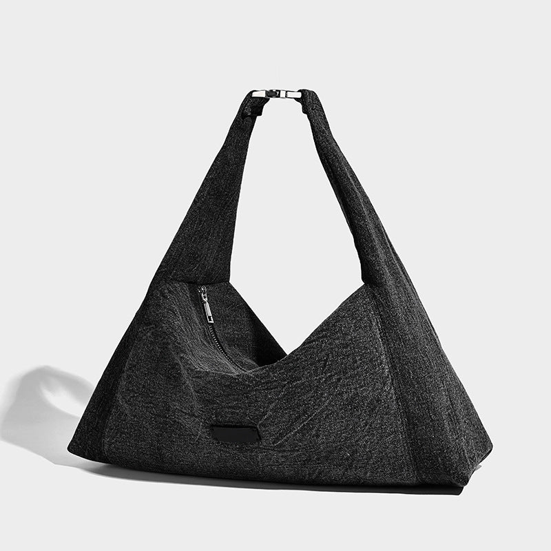 Oversized slouchy denim-look hobo shoulder bag with wide adjustable strap and top zipper closure, front view