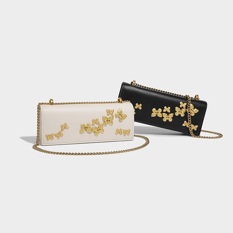 Slim rectangular crossbody bag with gold-tone butterfly metal appliqués and fine antiqued chain strap, detail view 2