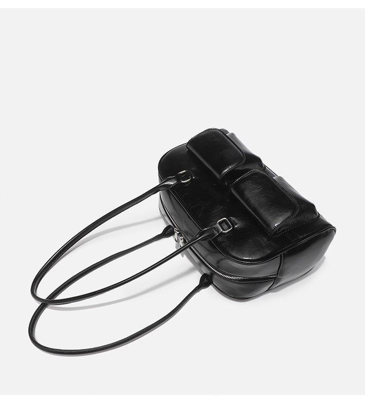 Structured glossy leather-look bowling shoulder bag with two front flap pockets, top zip closure, and long double shoulder
