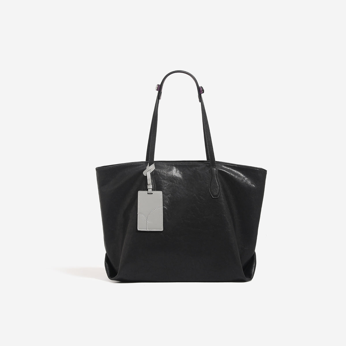 Oversized slouchy leather-look tote bag with long shoulder straps, contrast grey hanging tag, and silver-tone hardware