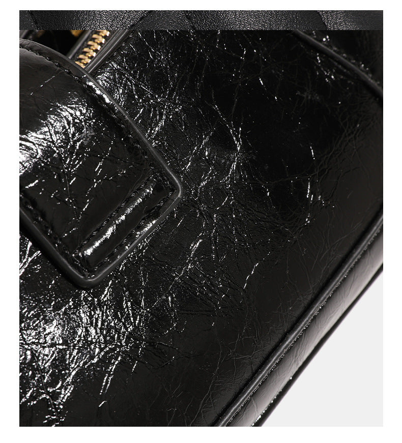 Compact glossy crinkled baguette shoulder bag with amber resin bead strap accent and gold-tone turn-lock closure, detail view