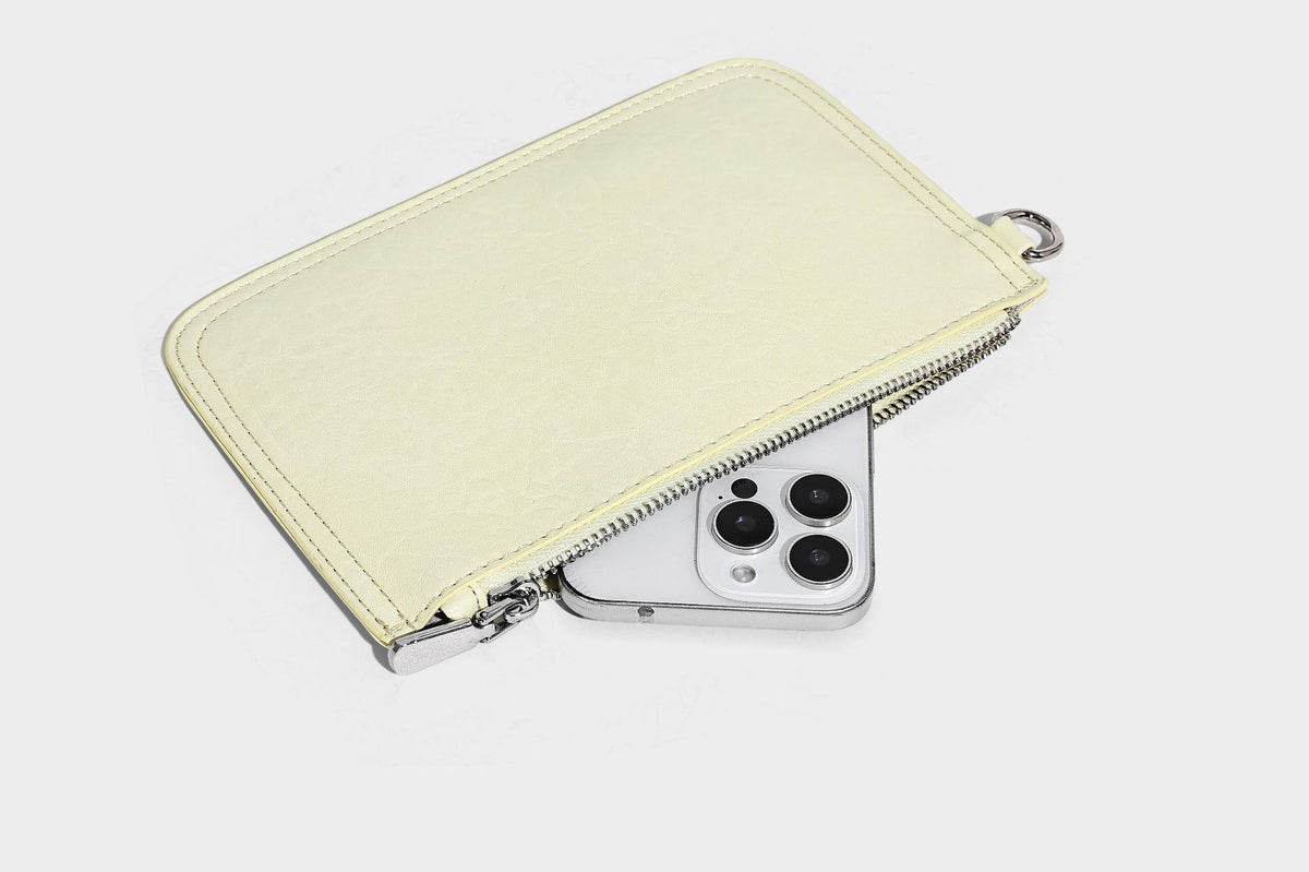 Slouchy hobo shoulder bag in pale yellow glossy pebbled leather-look finish with single shoulder strap and detachable front