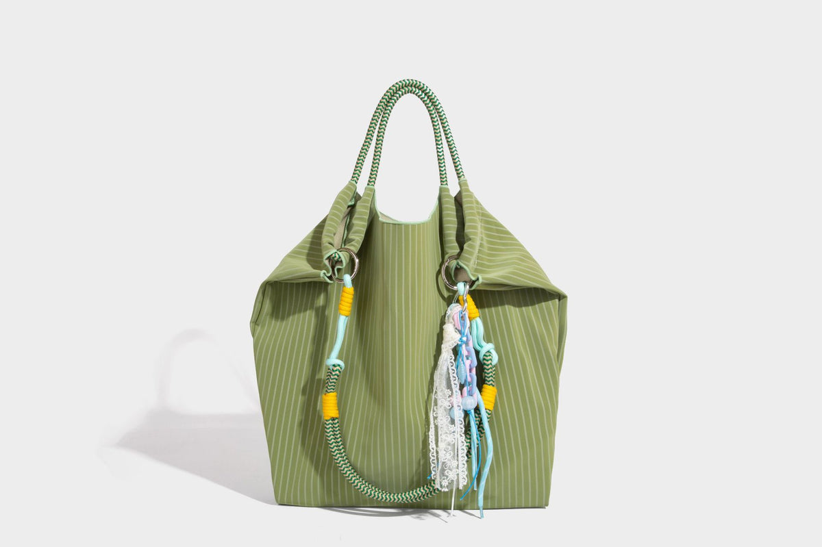 Slouchy pinstripe tote bag with braided rope handles, metal ring hardware, and colorful knotted rope charm, detail view 34