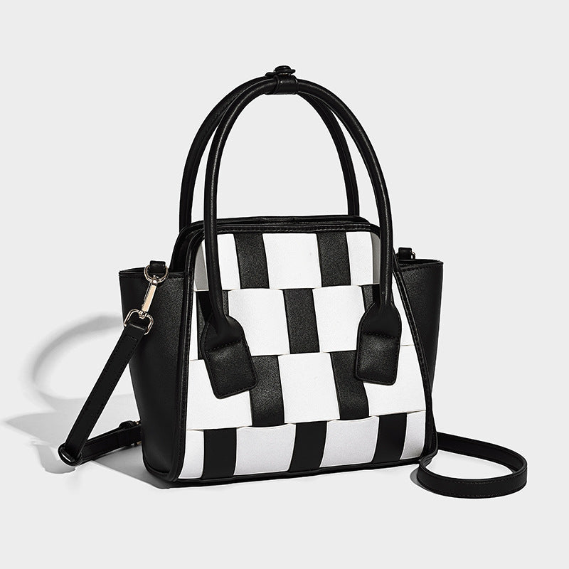 Small structured tote bag with black-and-white woven checker front panel, smooth matte side panels, dual rounded top handles