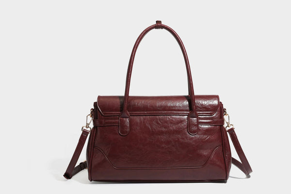 Structured glossy leather-look satchel bag with flap closure, gold-tone buckle accents, double top handles, detachable