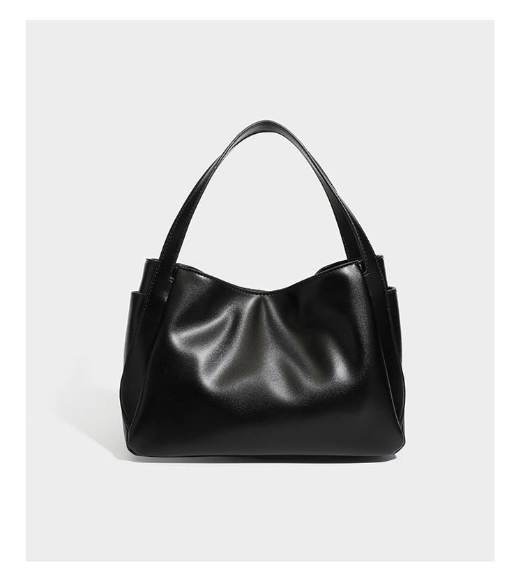 Structured glossy leather-look tote shoulder bag with dual top handles, detachable crossbody strap, side pockets, and, detail