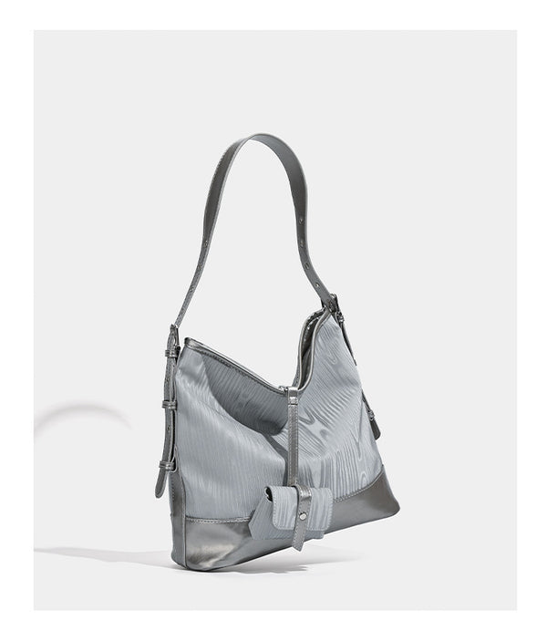 Lässig geformte Hobo-Schultertasche in Silbergrau mit holzmaserungsgeprägten Einsätzen, glänzender Metallic-Einfassung, Reißverschluss oben und vorderem Überschlag