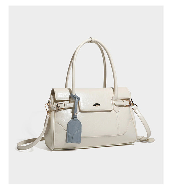 Structured glossy leather-look satchel bag with flap closure, gold-tone buckle accents, double top handles, detachable