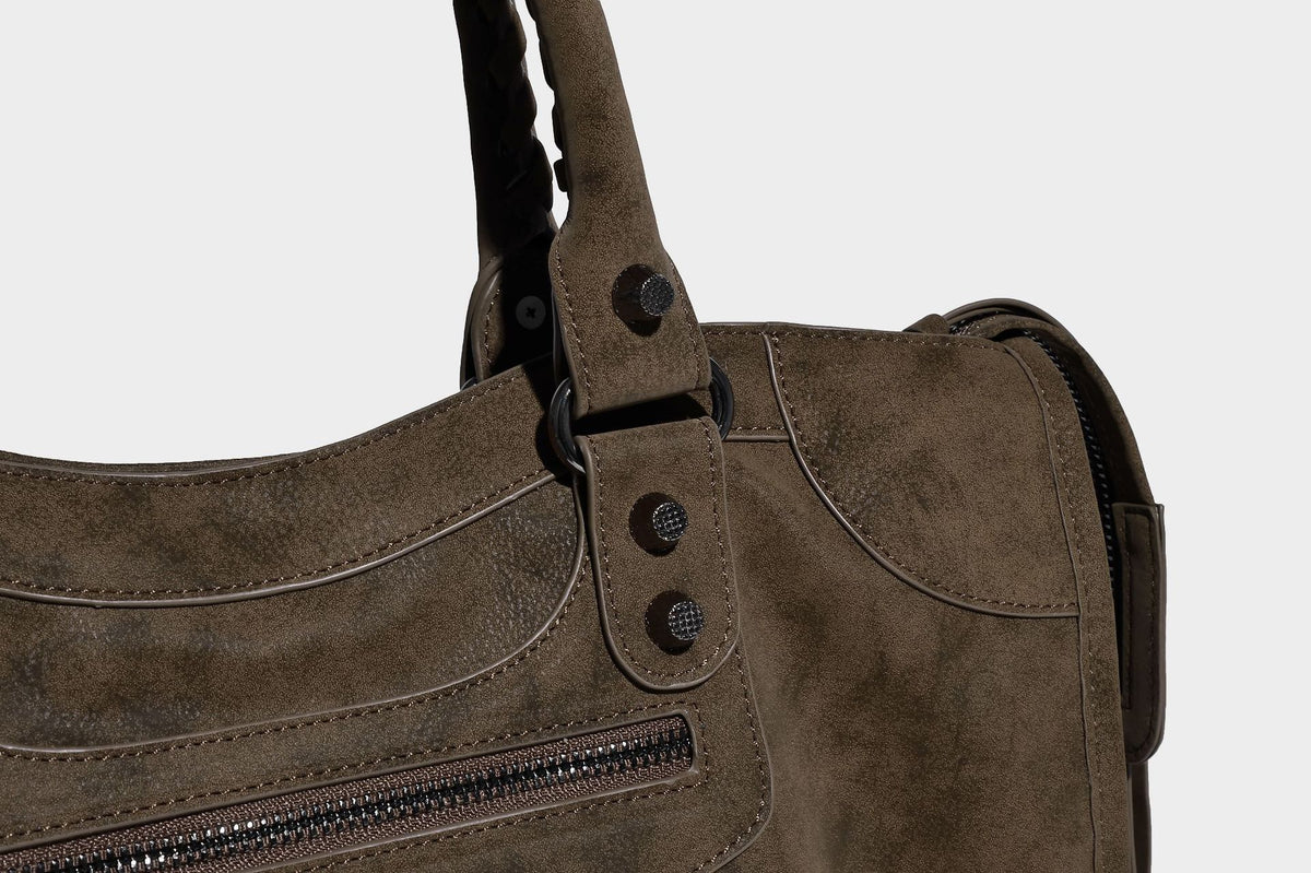 Strukturierte Henkeltasche in matter Velourslederoptik mit geflochtenen Tragegriffen, dunklen Nietenbeschlägen, vorderer Reißverschlusstasche und abnehmbarem