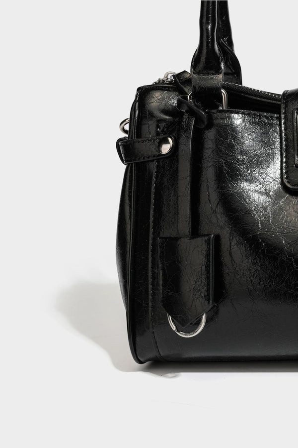 Structured glossy crinkled leather-look satchel with double top handles, front metal-plaque tab, silver-tone hardware, and