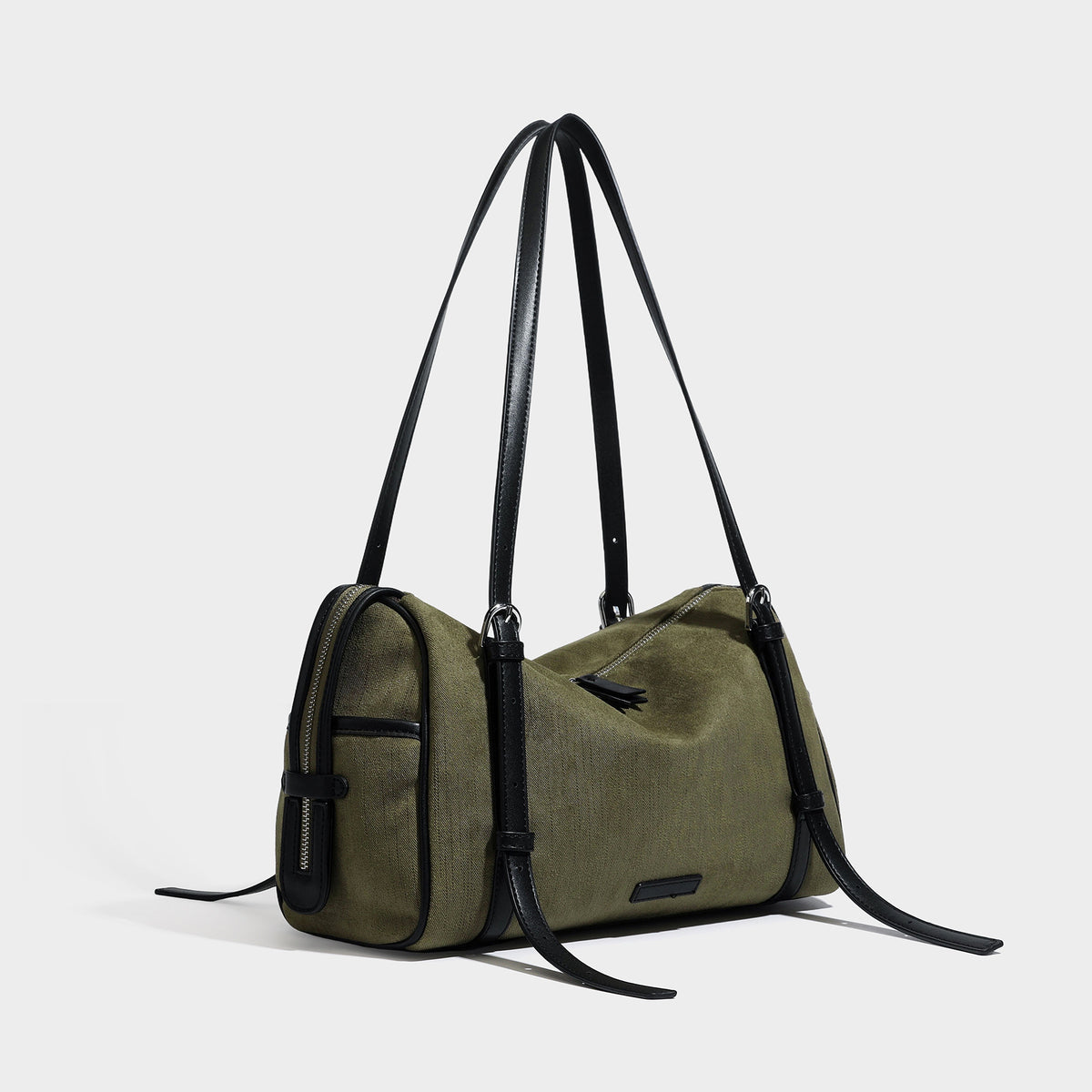Schultertasche in Olivgrün aus Canvas im Zylinderstil mit Riemen in schwarzer Lederoptik, Reißverschluss oben und silberfarbenen Beschlägen, Detailansicht