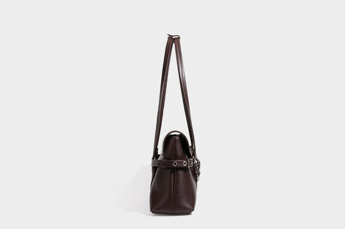 Strukturierte rechteckige Schultertasche mit Überschlagverschluss, vorderem Schnallengurt-Detail und ringförmigen Beschlägen in