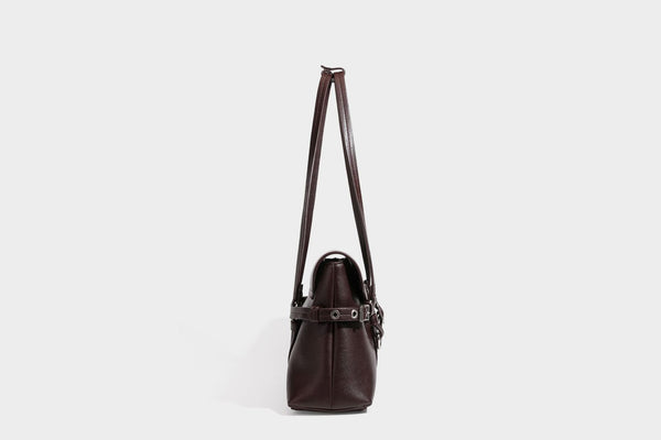 Strukturierte rechteckige Schultertasche mit Überschlagverschluss, vorderem Schnallengurt-Detail und ringförmigen Beschlägen in
