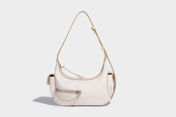 Smooth leather-look crescent shoulder bag with front zip pocket, side flap pockets, adjustable strap, and silver-tone, detail