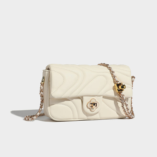 Compact cream quilted flap crossbody bag with wave stitching, gold-tone chain strap, and four-petal turn-lock clasp, detail