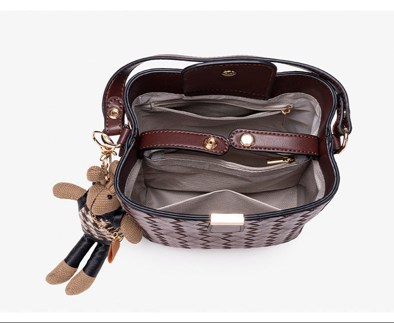 Brown woven-emboss leather-look bucket bag with short top handle, detachable crossbody strap, gold-tone hardware, and rabbit