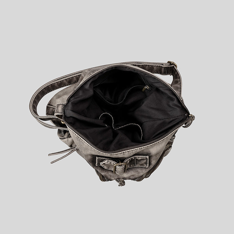 Distressed gunmetal gray hobo shoulder bag with multiple front zip pockets and adjustable crossbody strap, detail view 4