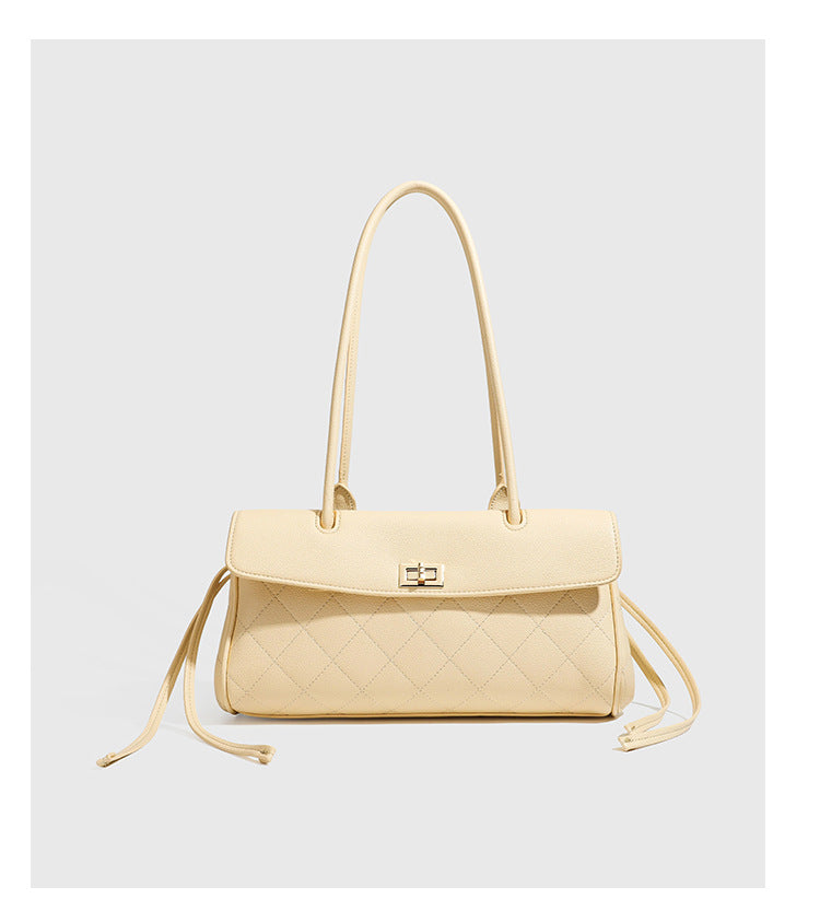 Structured black diamond-quilted shoulder bag with gold-tone turn-lock flap closure and dual round shoulder straps, detail
