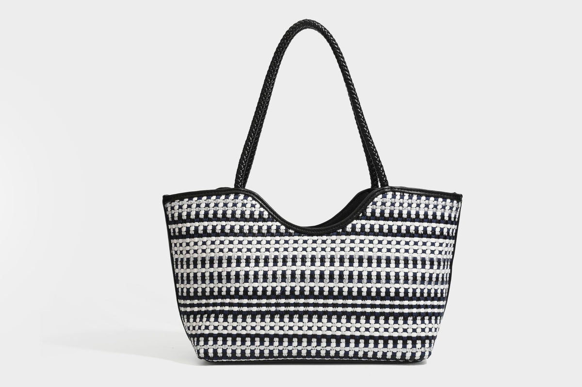 Large woven checker-pattern tote bag with dark braided shoulder straps, leather-look trim, and drawstring side ties, detail