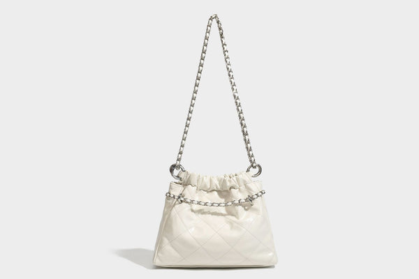 Glossy diamond-quilted drawstring bucket bag with silver chain shoulder strap and medallion charm, detail view 24