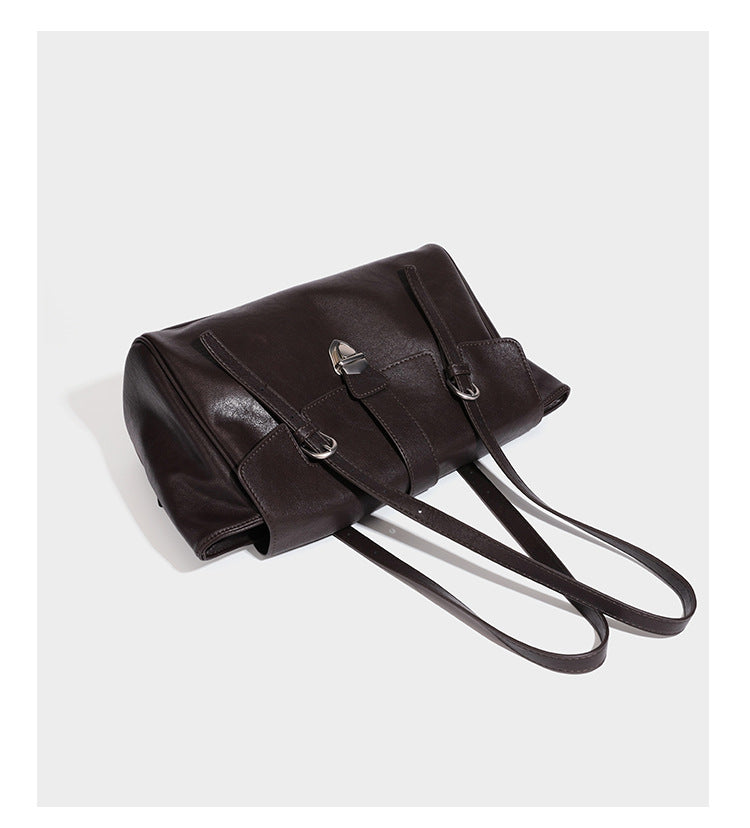 Large structured vintage-style tote bag with flap-front turn-lock closure, twin buckle straps, and double shoulder handles