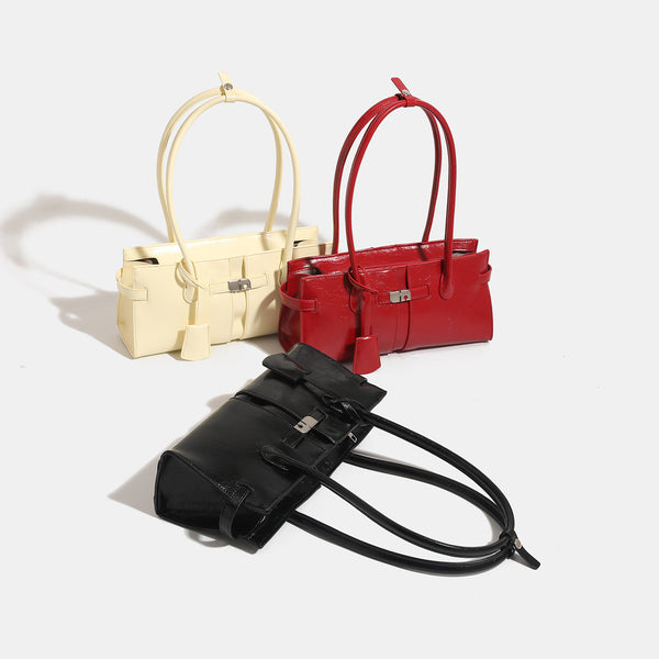 Structured glossy leather-look tote bag with long loop handles and silver turn-lock buckle closure, detail view 2