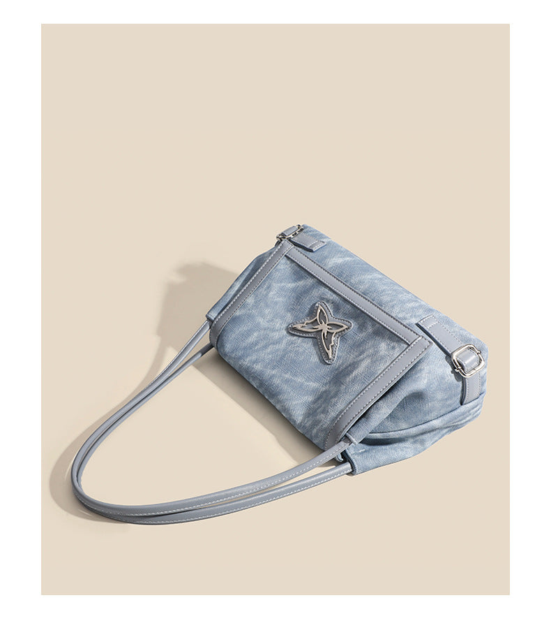 Washed leather-look shoulder tote bag with silver butterfly emblem and buckle hardware, detail view 13