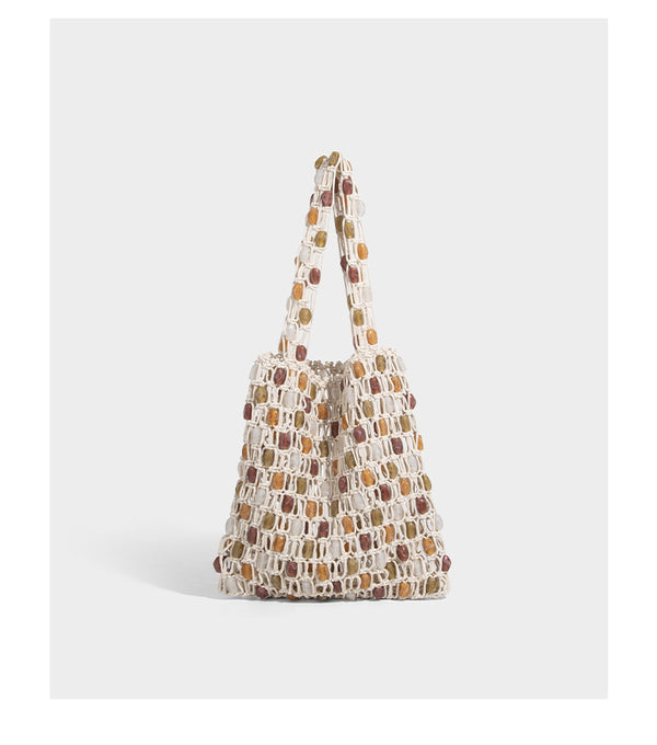 Cream macramé open-weave tote bag with multicolor amber olive and translucent bead accents and woven shoulder straps, detail