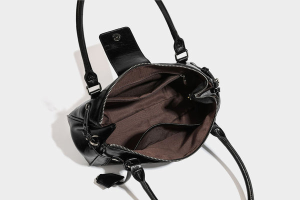 Structured glossy crinkled leather-look satchel with double top handles, front metal-plaque tab, silver-tone hardware, and