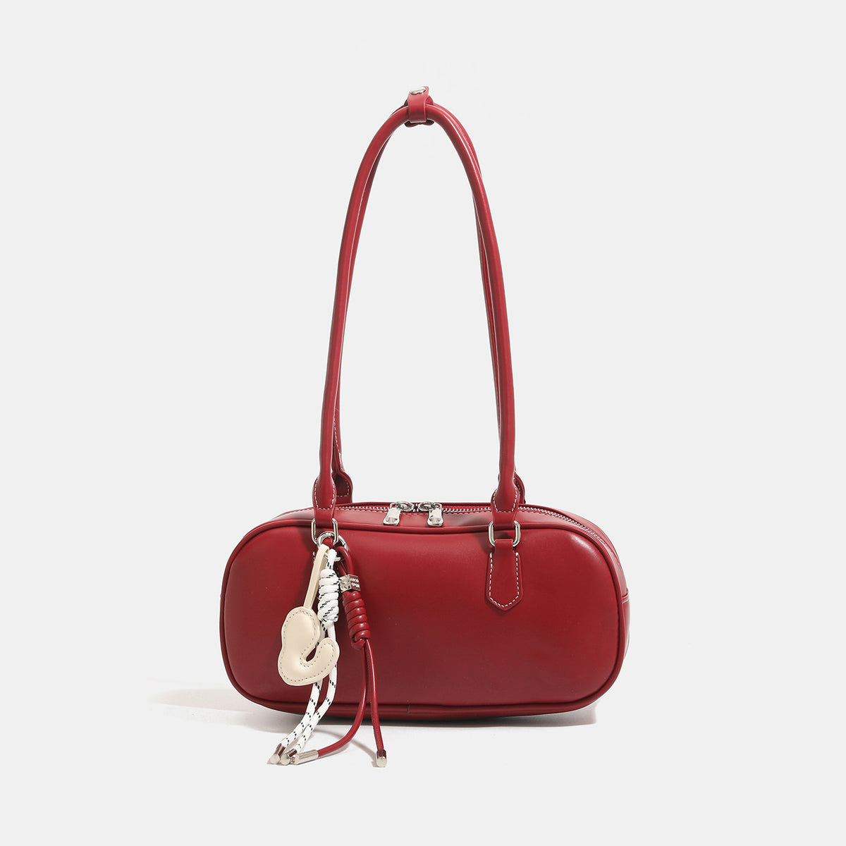 Compact rounded baguette shoulder bag with smooth leather-look finish, slim double straps, silver-tone zipper hardware, and