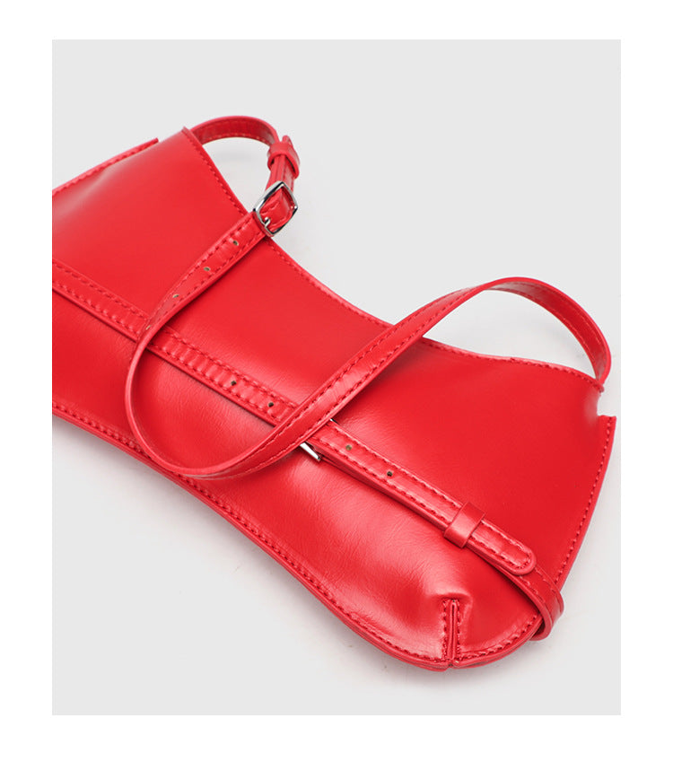 Curved baguette shoulder bag with front buckle strap and adjustable thin strap in glossy leather-look finish, detail view 15