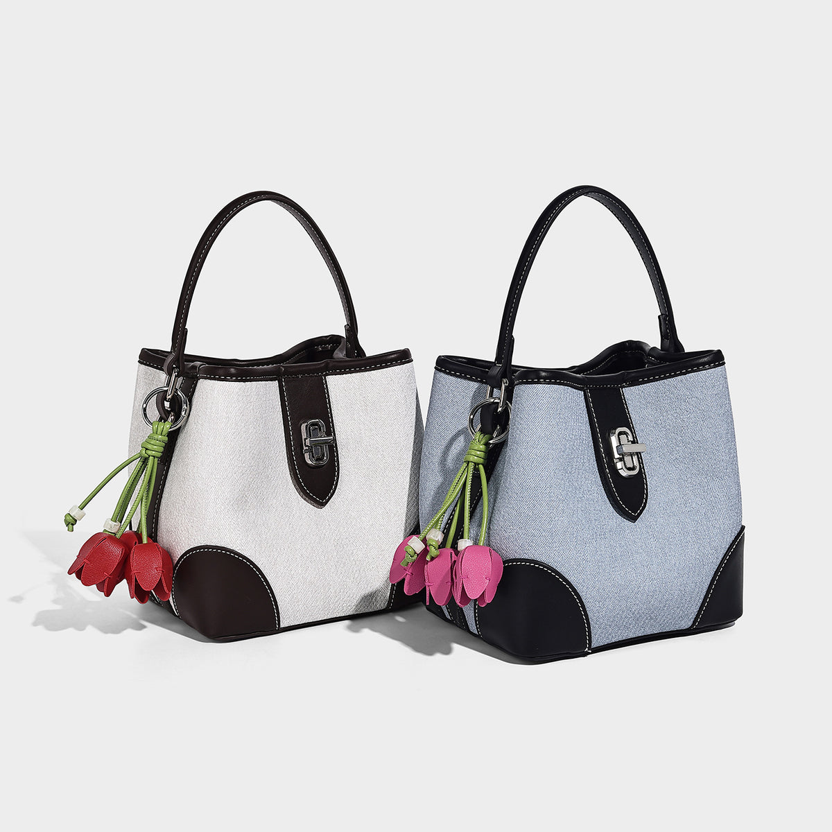 Small structured bucket bag in denim-look light blue fabric with black leather-look trim, silver turn-lock hardware, short