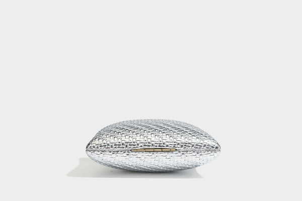 Small structured rectangular metallic woven-texture clutch bag with jeweled knob clasp and gold-tone chain strap, detail view