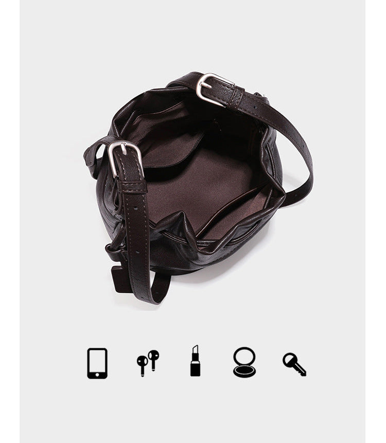 Kleine dunkelbraune Beuteltasche mit Kordelzug, langem verstellbarem Crossbody-Riemen und silberfarbenen Beschlägen, Detailansicht 10