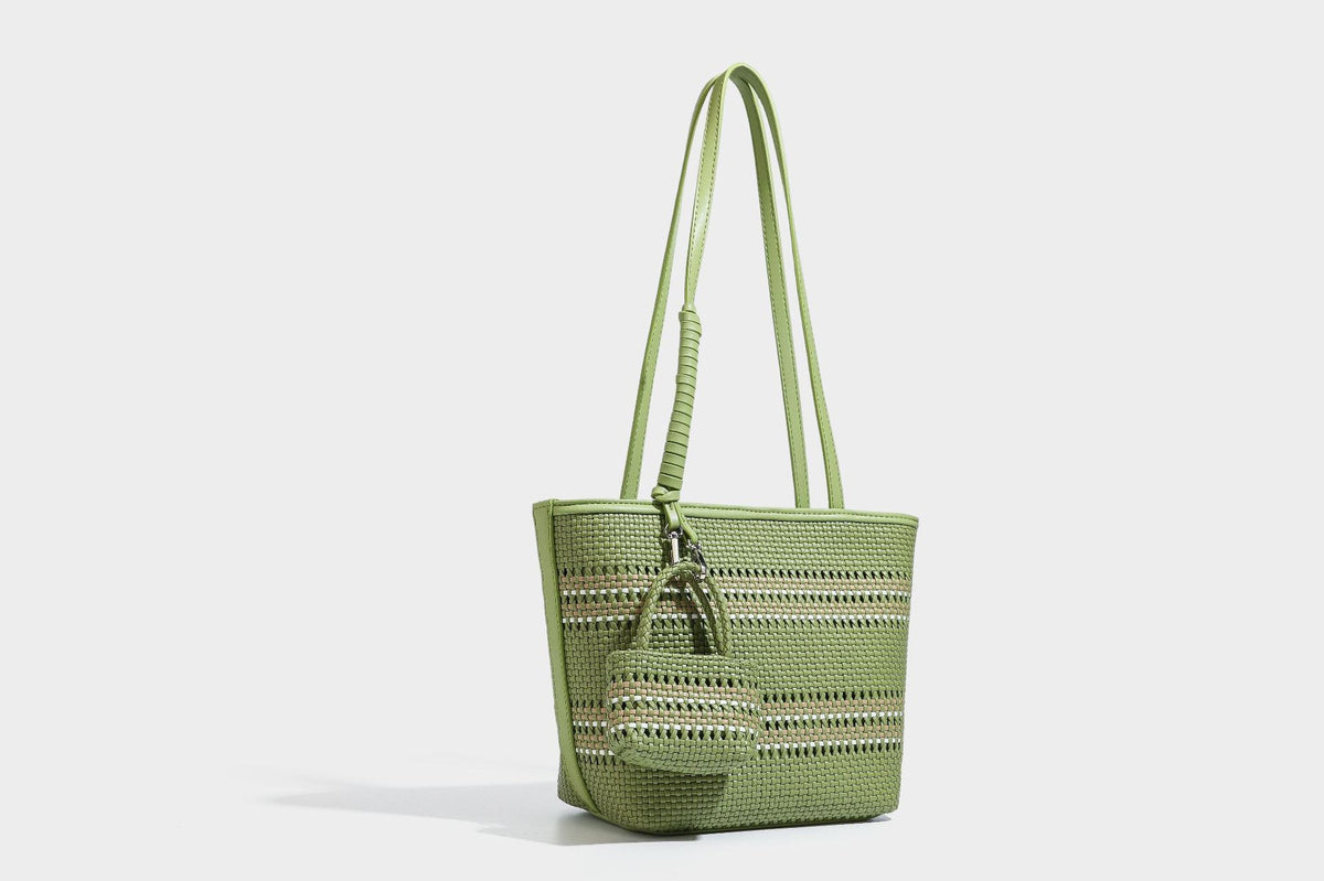 Large structured woven tote bag with striped basket-weave finish, long shoulder straps, and detachable mini pouch charm
