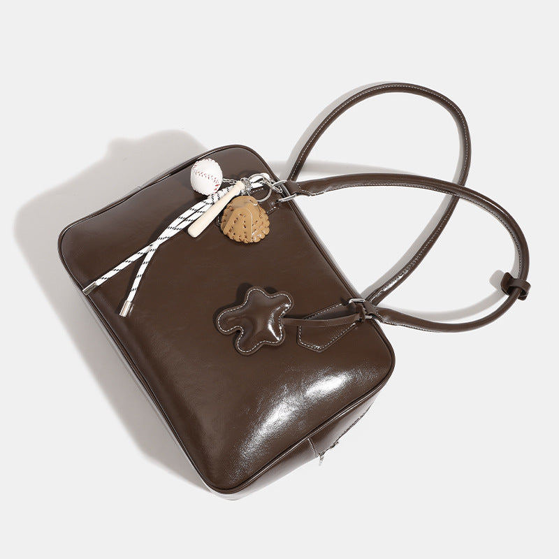 Große glänzende Boston-Tasche in Kunstlederoptik mit zwei Tragegriffen, Sternapplikation auf der Vorderseite und abnehmbarem Baseball-Anhänger-Set, Detailansicht