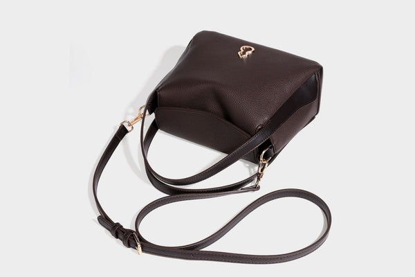 Structured pebbled leather-look shoulder bag with flap top, gold-tone emblem hardware, dual top handles, and detachable