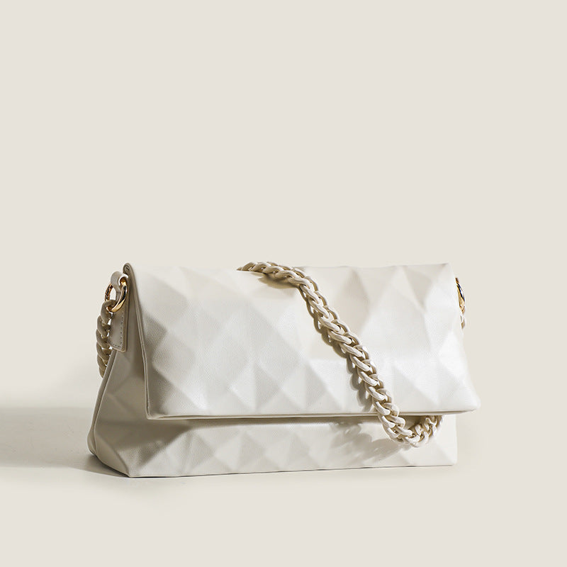 Cream white rectangular flap shoulder bag with geometric faceted surface and chunky tone-on-tone chain strap with gold-tone