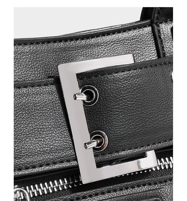 Black structured rectangular satchel bag with silver-tone rivets, large front buckle strap, zip pockets, dual top handles