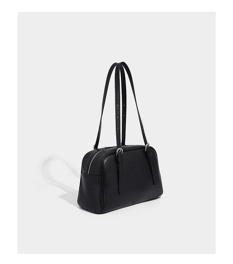Structured dome-shaped shoulder bag with leather-look finish, top zipper closure, dual adjustable slim straps, and, detail