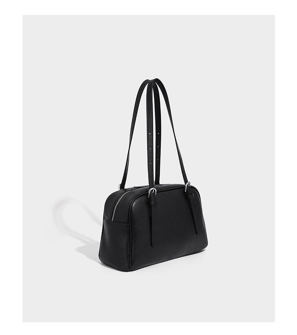 Structured dome-shaped shoulder bag with leather-look finish, top zipper closure, dual adjustable slim straps, and, detail