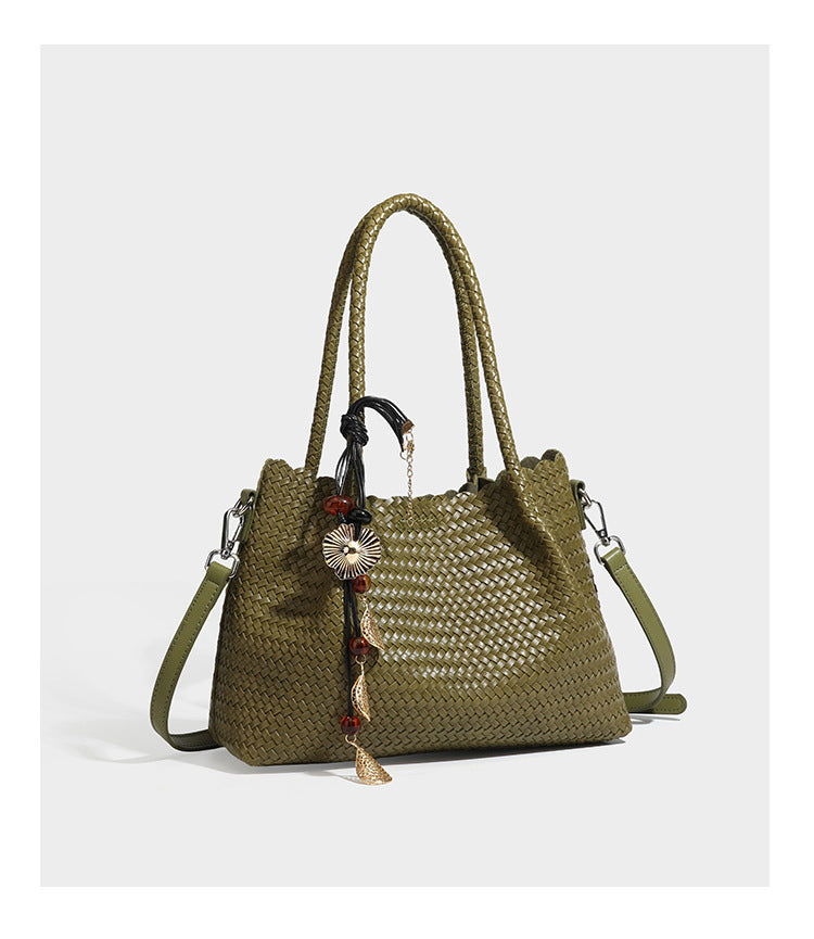 Strukturierter, glänzend geflochtener Shopper mit Muschelkantenabschluss am oberen Rand, geflochtenen Tragegriffen, abnehmbarem Crossbody-Riemen und Perlenquaste
