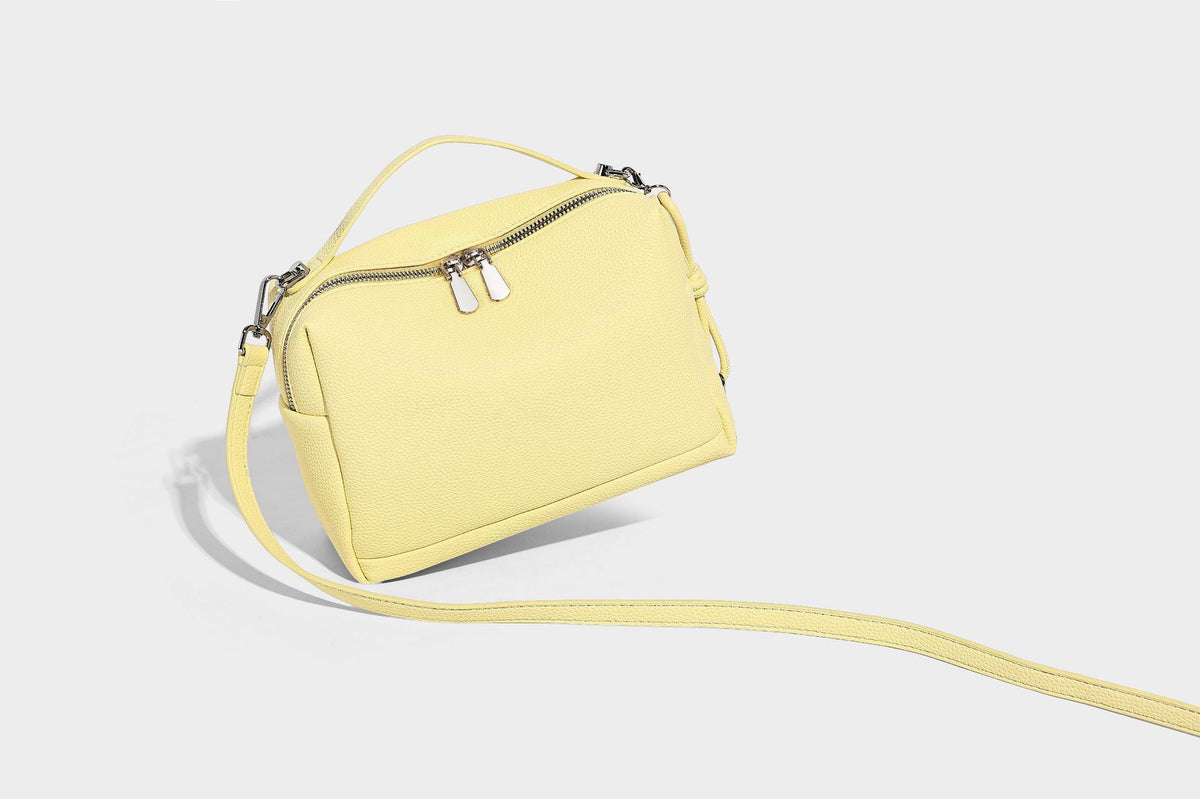 Kleine, strukturierte Crossbody-Tasche mit genarbter Oberfläche, Henkel, Reißverschluss, silberfarbener Hardware und optionalem Quastenanhänger