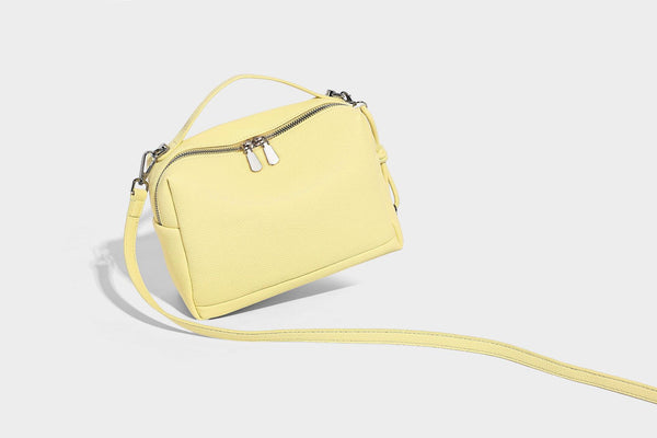 Kleine, strukturierte Crossbody-Tasche mit genarbter Oberfläche, Henkel, Reißverschluss, silberfarbener Hardware und optionalem Quastenanhänger