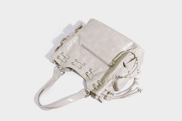 Glossy crinkled leather-look tote bag with silver grommet lace-up front detail, dual top handles, and detachable shoulder