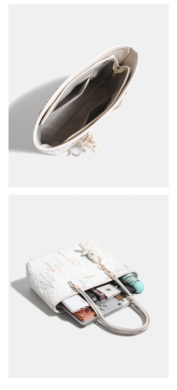 Off-white structured tote bag with dual shoulder straps, gold-tone hardware, and plush bear charm, detail view 13