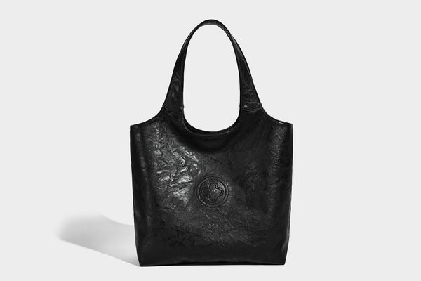 Large open-top tote bag with crinkled leather-look finish, long double shoulder straps, and embossed circular detail on