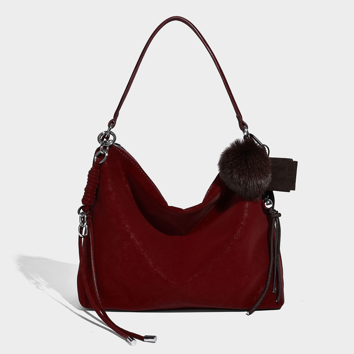 Slouchy matte-finish hobo shoulder bag with tassel cords, silver-tone hardware, and faux-fur pom charm, detail view 10