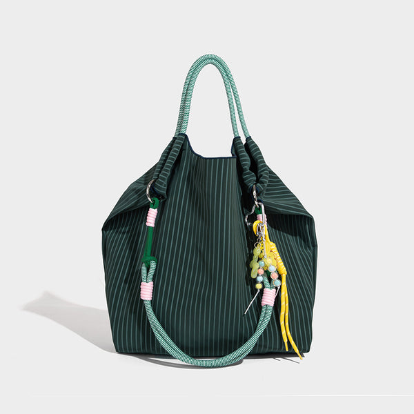 Slouchy pinstripe tote bag with braided rope handles, metal ring hardware, and colorful knotted rope charm, detail view 7